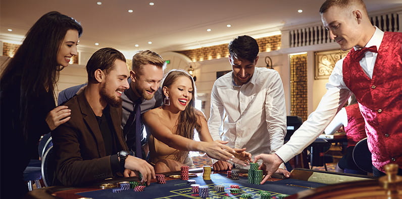 Group of people having fun playing around a casino table